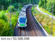 Railroad travel and railway tourism transportation industrial concept: scenic summer view of modern high speed passenger commuter train on tracks with motion blur effect. Стоковое фото, агентство Ingram Publishing / Фотобанк Лори