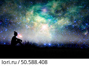 Silhouette of a woman sitting outside, starry night background. Стоковое фото, агентство Ingram Publishing / Фотобанк Лори