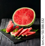Watermelon on a slate over black background. Стоковое фото, агентство Ingram Publishing / Фотобанк Лори