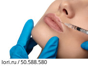 Portrait of young woman getting cosmetic injection of botox, isolated over white background. Стоковое фото, агентство Ingram Publishing / Фотобанк Лори