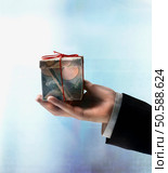 Businessman’s hand holding gift box made of Yen. 24316755. Стоковое фото, агентство Ingram Publishing / Фотобанк Лори