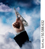 Businessman’s hand holding airplane made of British Pounds. 24316764. Стоковое фото, агентство Ingram Publishing / Фотобанк Лори