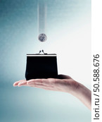 Coin falling into change purse in woman’s hand. 24316814. Стоковое фото, агентство Ingram Publishing / Фотобанк Лори