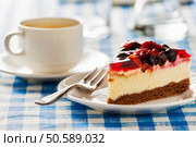 Dessert background - fruit cheese cake on plate with fork and coffee cup on blue checkered tablecloth. Стоковое фото, агентство Ingram Publishing / Фотобанк Лори