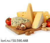Board with assortment of delicious cheese, tomatoes and nuts on white background. Стоковое фото, агентство Ingram Publishing / Фотобанк Лори