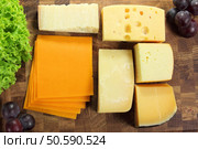 Hard cheeses served on a wooden board. Стоковое фото, агентство Ingram Publishing / Фотобанк Лори