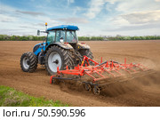 Small scale farming with tractor and plow in field . Стоковое фото, агентство Ingram Publishing / Фотобанк Лори