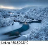 Aerial drone view of frozen lake, waterfall and snowy forest at sunset. Winter fairytale in Plitvice Lakes, Croatia. Top view of white snow-covered trees, waterfall, trails, fog, cloudy sky. Nature. Стоковое фото, агентство Ingram Publishing / Фотобанк Лори
