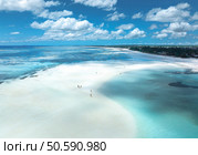 Aerial view of island during low tide, sandbank in ocean, white sandy beach, people, blue sea on sunny summer day in Zanzibar. Top view of sand spit, clear water, sky with clouds. Tropical background. Стоковое фото, агентство Ingram Publishing / Фотобанк Лори