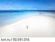 Aerial view of alone young woman on the sandbank in ocean, white sand, blue sea during low tide at sunny summer day in Nakupenda, Zanzibar island. Top view of girl, sand spit, water, sky with clouds. Стоковое фото, агентство Ingram Publishing / Фотобанк Лори