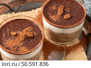 Indulge in a luscious tiramisu-inspired chia pudding, layered with creamy coffee-infused chia and a rich chocolate topping. A delightful breakfast or dessert option that combines classic tiramisu flavors with wholesome ingredients for a convenient and satisfying treat. Стоковое фото, агентство Ingram Publishing / Фотобанк Лори