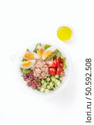 Tasty vitamin salad bowl made with tuna, cucumber, eggs, tomato, olives and oil isolated on white background. Lunch concept. Tasty vitamin salad bowl isolated on white background. Стоковое фото, агентство Ingram Publishing / Фотобанк Лори