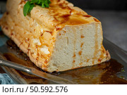 A tempting close-up features a slice of molotof, a traditional caramelized egg white pudding, generously drizzled with sweet syrup and garnished with fresh green mint leaves. Стоковое фото, агентство Ingram Publishing / Фотобанк Лори