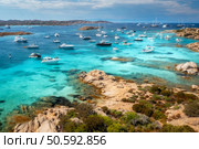 Aerial view of luxury yachts and boats moored in the crystal-clear turquoise waters of a beautiful sea bay in sardinia, italy, creating a picturesque scene of summer vacation and leisure. Top view. Breathtaking aerial view over the maddalena archipelago in sardinia, italy, featuring luxury yachts and boats anchored in crystal-clear turquoise waters amid rocky coastlines and lush vegetation. Стоковое фото, агентство Ingram Publishing / Фотобанк Лори