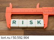 Measuring word RISK with vernier caliper tool on wooden table background. Planning, risk management or evalution and business finance strategy concept.. Measuring,Word,Risk,With,Vernier,Caliper,Tool,On,Wooden,Table. Стоковое фото, агентство Ingram Publishing / Фотобанк Лори