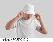 Mockup of white panama on posing guy in t-shirt, sun hat, blank accessory for design, print, brand, advertising. Fashion unisex headgear template, isolated on background. Spring, summer headdress. Mockup,Of,White,Panama,On,Posing,Guy,In,T-shirt,,Sun. Стоковое фото, агентство Ingram Publishing / Фотобанк Лори