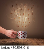Steaming cup of coffee and coffee beans. Стоковое фото, агентство Ingram Publishing / Фотобанк Лори