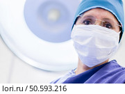 Female surgeon wearing a facemask and a hat. Стоковое фото, агентство Ingram Publishing / Фотобанк Лори