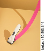 Hair clipper moves and leaves behind it pink thick line. Creative professional approach to the work of hairdresser. Visual scene of style, fashion and trends. Стоковое фото, агентство Ingram Publishing / Фотобанк Лори