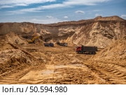 From afar - the work of a sand quarry. There is a lot of equipment, the development of minerals is underway. Стоковое фото, фотограф Дина Дамоцева / Фотобанк Лори