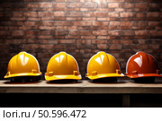 Four safety helmets resting on wooden shelf in front of brick wall. Стоковое AI-изображение, AI-художник Иван Рябоконь / Фотобанк Лори