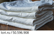 Neatly folded white t-shirts stacked on a wooden surface. Many folded white basic cotton linen presented in rustic interior. Minimalist clothing organization and clean laundry concept. Стоковое AI-видео, аниматор Sergey Grishin / Фотобанк Лори