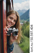 Beautiful happy young woman hangs out of train open window and make photo on vintage analog camera. Travel and explore more wanderlust concept. Female touristin. Стоковое AI-видео, аниматор Sergey Grishin / Фотобанк Лори
