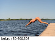 Athletic woman in swimsuit diving headfirst from a pier into the lake. Sunny summer day, dynamic outdoor action. Стоковое фото, фотограф Скоробогатова Е. / Фотобанк Лори