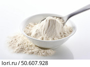 Spoon scooping flour from a bowl on white background. Стоковое AI-изображение, AI-художник Иван Рябоконь / Фотобанк Лори