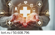 Close-up of a person's hands gently cradling a glowing, white, three-dimensional medical symbol, which is a cross with a many doodle symbols around it. healthcare and hospitality concept. Стоковое AI-видео, аниматор Sergey Grishin / Фотобанк Лори