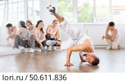 Visitors to studio, observe professional male break dance rendering of elements performances couch. Стоковое фото, фотограф Яков Филимонов / Фотобанк Лори