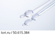 Clear glass pipettes filled with liquid creating droplets during laboratory research on a clean surface. Стоковое AI-изображение, AI-художник Сергей Толмачёв / Фотобанк Лори
