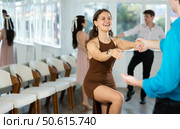 Couple in evening dresses enjoys pair dance boogie-woogie, interacting with each other on floor. Стоковое фото, фотограф Яков Филимонов / Фотобанк Лори