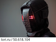 Cyberpunk warrior wearing futuristic helmet with glowing red lights. Стоковое AI-изображение, AI-художник Иван Рябоконь / Фотобанк Лори
