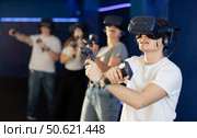 Guy with handheld controllers and VR glasses playing virtual game. Стоковое фото, фотограф Яков Филимонов / Фотобанк Лори