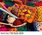 Crochet granny square, clews and hook on crochet blanket background photo. Стоковое фото, фотограф Елена / Фотобанк Лори