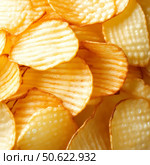Close-up of delicious ribbed potato chips. Стоковое AI-изображение, AI-художник Анастасия / Фотобанк Лори