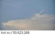 White contrail from a jet plane flying high in the blue sky. Стоковое видео, видеограф Mikhail Davidovich / Фотобанк Лори