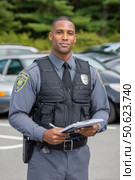 Police officer writing on clipboard in parking lot. Стоковое AI-изображение, AI-художник Юрий Поздников / Фотобанк Лори