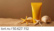 Yellow Sunscreen cream tube, starfishes and seashells on a sand top view. Cosmetic mockup. Sunblock lotion on sandy beach background. Summer vacation care concept, sun screen product, spf uv protect. Стоковое AI-изображение, AI-художник Марина Демидюк / Фотобанк Лори