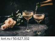 Champagne and red pink roses on a black concrete background. Copy space for text. Valentines drinks for for a pair of lovers. Bartender pours prosecco sparkling wine into glasses. Romance. Wedding Day. Стоковое AI-изображение, AI-художник Марина Демидюк / Фотобанк Лори
