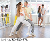 Young woman dances incendiary tango with man partner during choreography lesson. Стоковое фото, фотограф Яков Филимонов / Фотобанк Лори