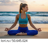 A woman is sitting on the beach and practicing yoga. Стоковое AI-изображение, AI-художник Ярославский Максим / Фотобанк Лори