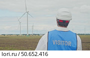 Engineer is watching correct operation of wind turbines with interest, which generate environmentally friendly energy from wind. Стоковое видео, видеограф Strunov David / Фотобанк Лори