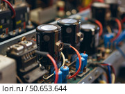 Close up of an electronic circuit board with capacitors, resistors, and wires. Стоковое AI-изображение, AI-художник Иван Рябоконь / Фотобанк Лори
