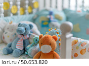 Adorable stuffed animals waiting in baby boy crib for newborn arrival. Стоковое AI-изображение, AI-художник Иван Рябоконь / Фотобанк Лори