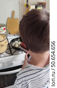 11 year old boy with hearing aids learning to cook, fry onions in a pan. Стоковое видео, видеограф Кашапова Эльвира / Фотобанк Лори