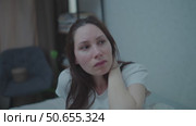 A young adult woman sits on a couch in the middle of the night, nervously twirling her hair. Panic attacks and mental health. Стоковое видео, видеограф Денис Кебедов / Фотобанк Лори
