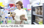 Interested woman visiting store to buy quality nutritious pet turtle food, reading ingredients on treat packages and contemplating choice. Стоковое видео, видеограф Яков Филимонов / Фотобанк Лори