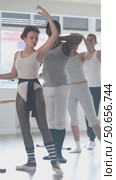 Group of concentrated amateur ballet enthusiasts practicing combination of forward and side battement tendu with arms in third position at barre, improving posture and grace in sunlit mirrored studio. Стоковое видео, видеограф Яков Филимонов / Фотобанк Лори